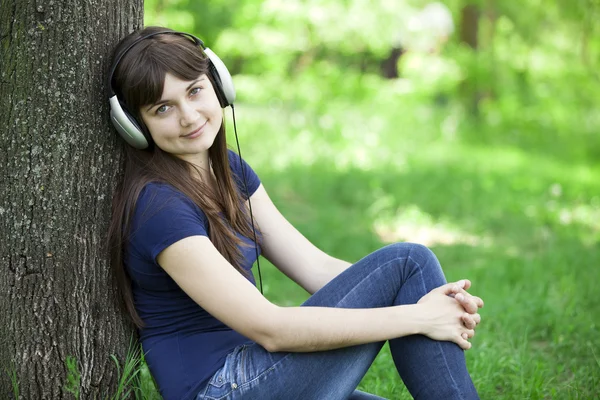 Chica de la moda joven con auriculares en la hierba verde primavera . —  Fotos de Stock