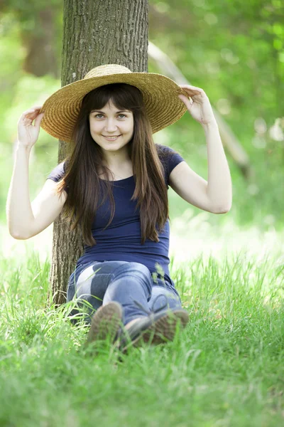 Junges Modemädchen mit weißem Hut im grünen Gras. — Stockfoto