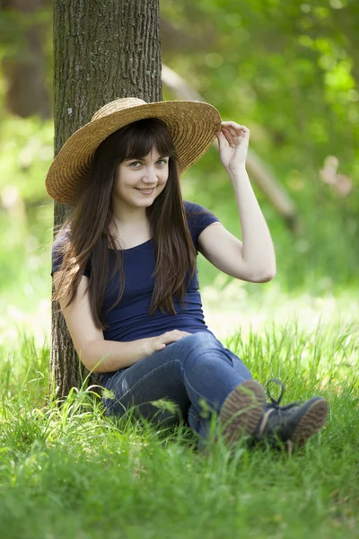 Jonge mode meisje in witte hoed op groen gras. — Stockfoto