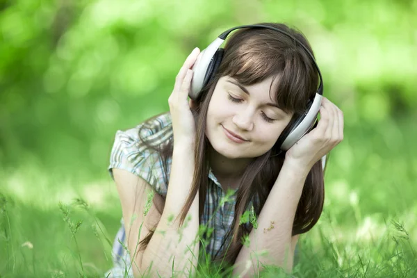 Młoda dziewczyna moda ze słuchawkami w zielonej trawie wiosna. Zdjęcia Stockowe bez tantiem