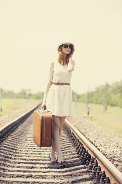 Ung flicka med resväska på järnvägar. — Stockfoto