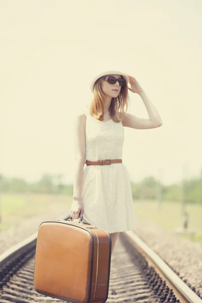 Menina de moda jovem com mala em ferrovias . — Fotografia de Stock