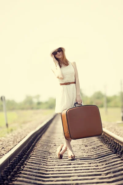 Chica de moda joven con maleta en los ferrocarriles . — Foto de Stock