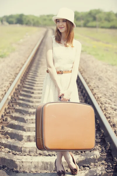 Mladá móda dívka s kufrem na železnice. — Stock fotografie