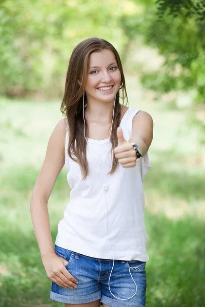 Menina adolescente bonita no parque com fones de ouvido . — Fotografia de Stock