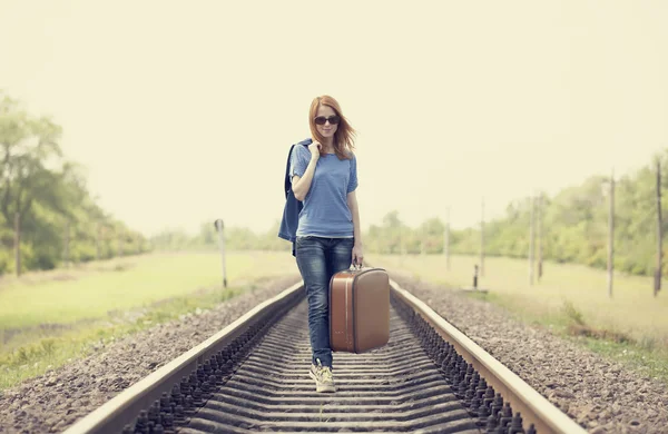 Young fashion girl with suitcase at railways. Stock Image