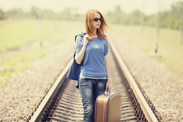 Young fashion girl with suitcase at railways. Stock Picture