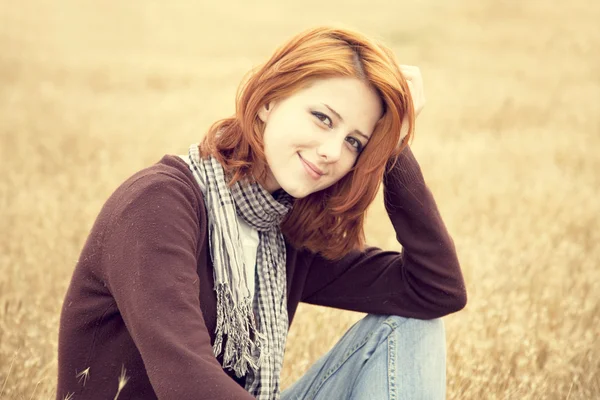 Sarı sonbahar çimen, güzel kızıl saçlı kız. — Stok fotoğraf
