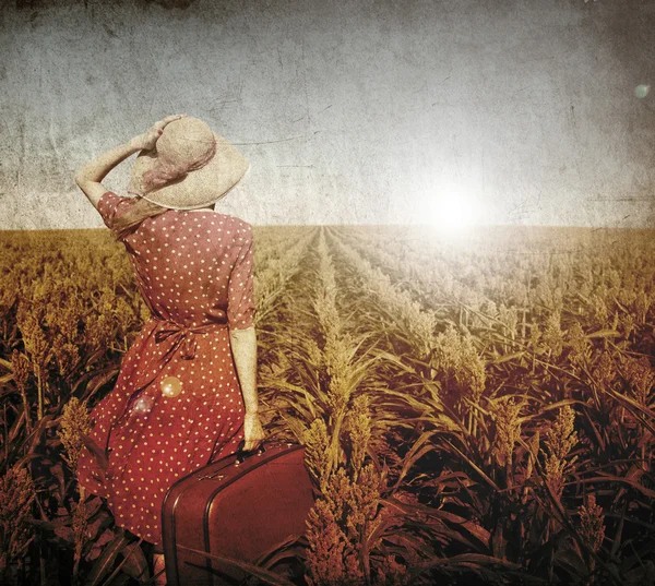 Roodharige meisje met koffer in maïsveld. — Stockfoto