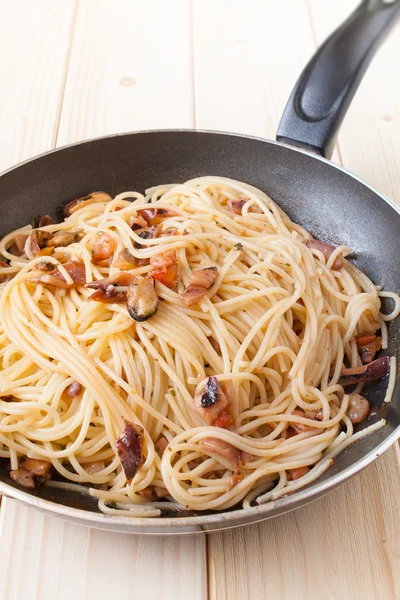 Spaghetti with clams into frying pan — Stock Photo, Image