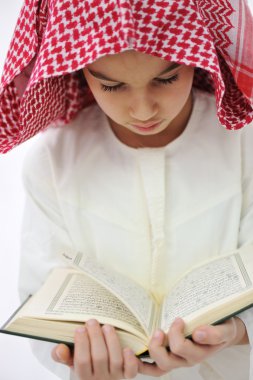 Muslim Arabic little boy reading Koran clipart