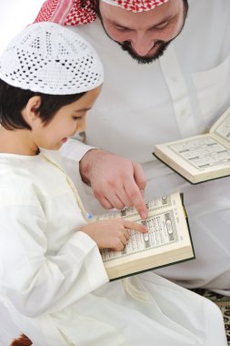 Muslim Arabic father and son recitating Koran clipart