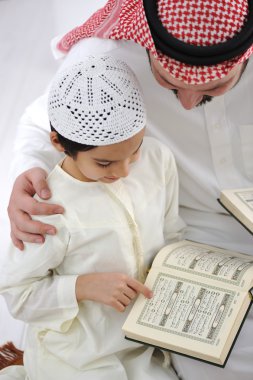 Father teaching little son Koran clipart