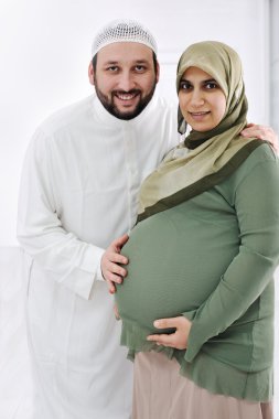 Portrait of a happy young pregnant muslim woman with her husband clipart