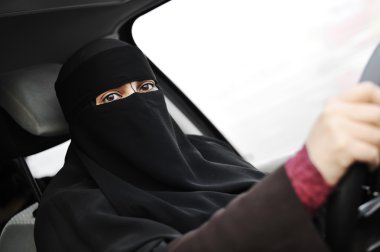 Arabic Muslim woman with veil and scarf (hijab and niqab) driving car clipart