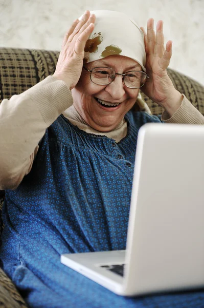 Elderly woman working on laptop in house — Stock Photo, Image
