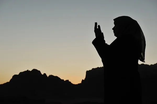Silhouet van een Moslimvrouw bidden op de woestijn — Stockfoto