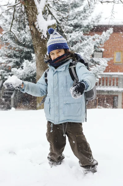 Boldog iskolás gyerek meleg ruhát visel a hóban — Stock Fotó
