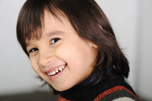 Bonito menino sorridente com cabelo comprido — Fotografia de Stock