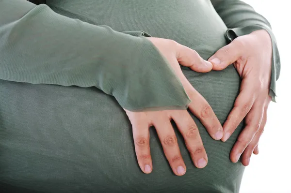 Kalp şekli ile yapım hamile Müslüman kadının karnının üzerinde eller — Stok fotoğraf