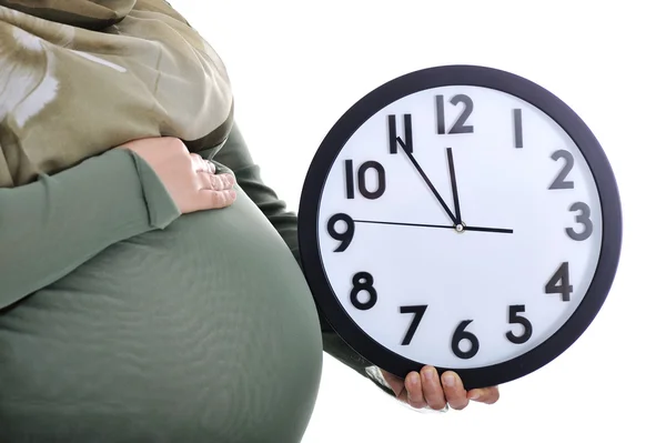 Tummy of pregnant muslim woman with clock — Stock Photo, Image