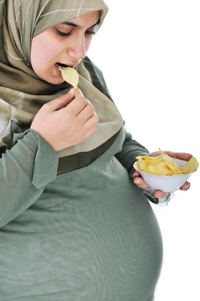 Gravid ganska muslimsk kvinna äter chips — Stockfoto