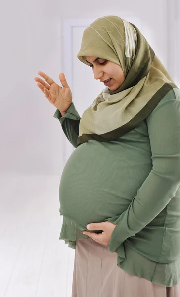 Mulher muçulmana grávida está conversando com seu bebê — Fotografia de Stock