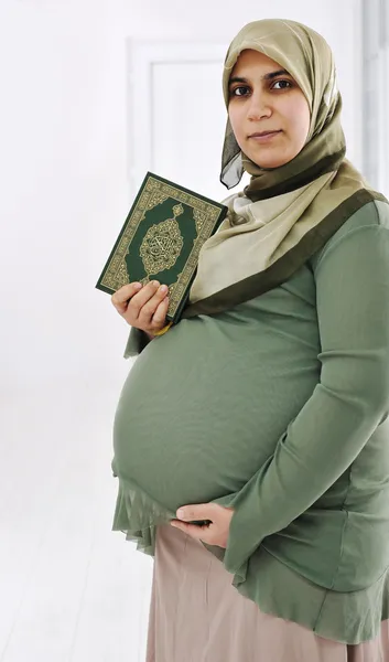 Έγκυος μουσουλμανική γυναίκα κρατά ελαιόπρινο Κοράνι — Φωτογραφία Αρχείου