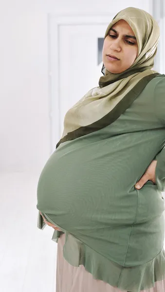 Schwangere Muslimin massiert ihren Rücken. horizontale Form — Stockfoto