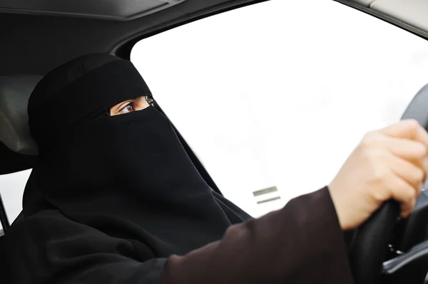 Arabische Moslimvrouw met sluier en sjaal (hijab en niqab) rijden auto — Stockfoto