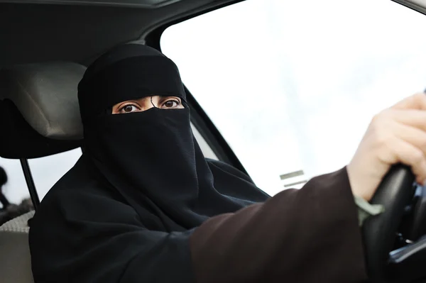 Арабская мусульманка с вуалем и шарфом (хиджаб и никаб) за рулем автомобиля — стоковое фото