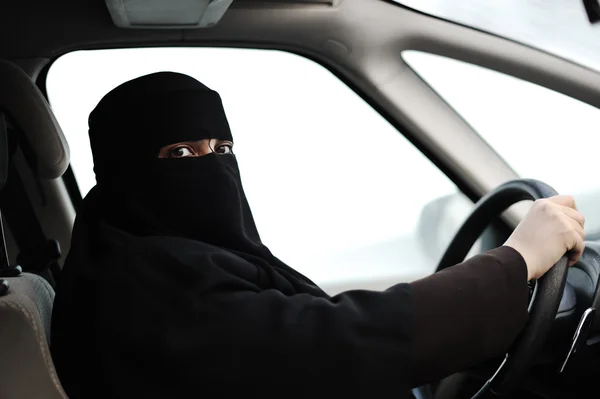 Arabic Muslim woman with veil and scarf (hijab and niqab) driving car — Stock Photo, Image