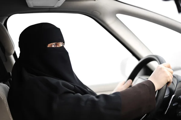 Arabisk muslimsk kvinna med slöja och halsduk (hijab och niqab) kör bil — Stockfoto