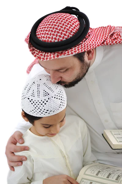 Middle eastern education, father kissing son while reading Koran Royalty Free Stock Photos