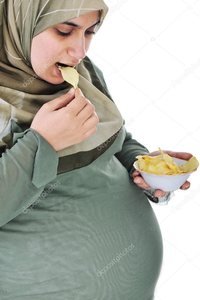 Pregnant pretty muslim woman eats chips