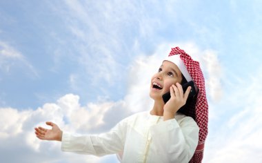 Arabic kid talking on phone outside clipart