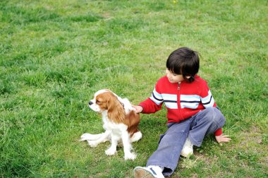 Young boy playing with a dog clipart