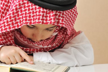 Muslim boy reading Koran clipart