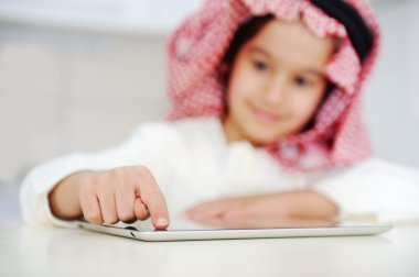 Arabic kid workin on tablet computer clipart