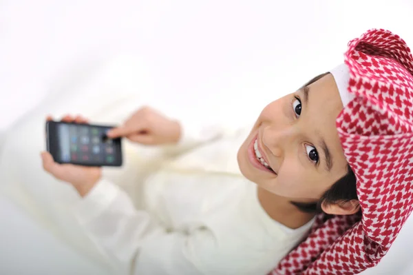 Kid met traditionele Midden-Oosten kleren spelen met slimme telefoon — Stockfoto