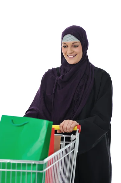 Glad muslimsk kvinna med kundvagn över vita — Stockfoto