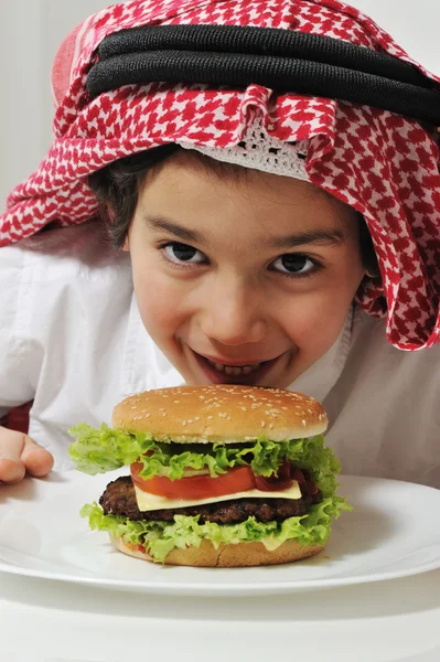 Niño árabe con hamburguesa — Foto de Stock