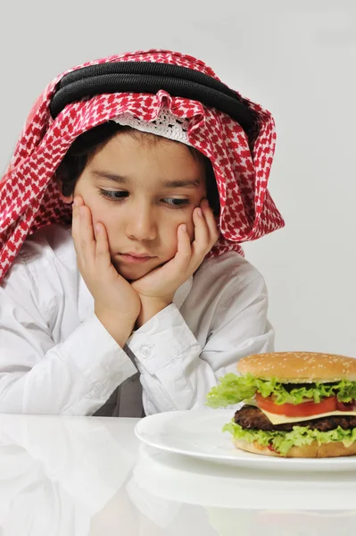 Unhappy Arabic kid with burger — Stock Photo, Image