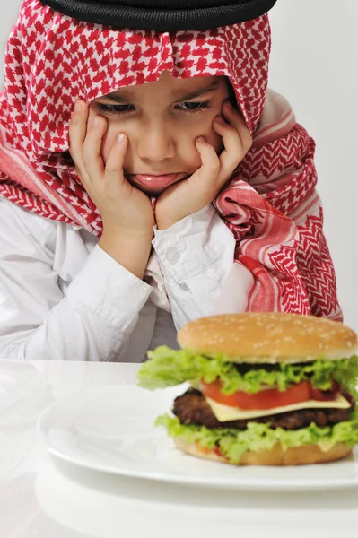 Miúdo árabe irritado com hambúrguer — Fotografia de Stock