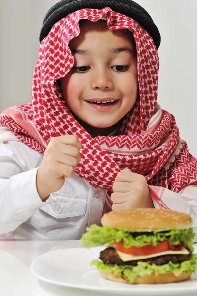 ハンバーガーと中東の小さな男の子 — ストック写真