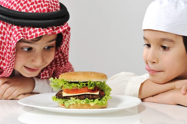 Büyük hamburger ile Arapça iki küçük çocuk — Stok fotoğraf