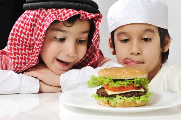Medio oriente dos niños pequeños con hamburguesa grande —  Fotos de Stock