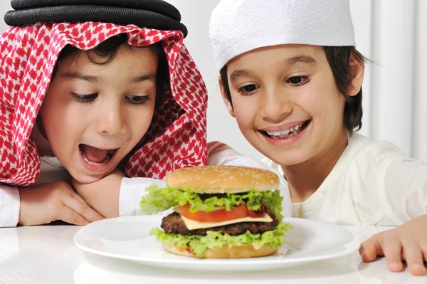 Twee kleine kinderen met grote hamburger — Stockfoto