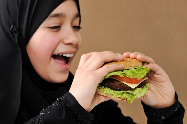 Menina árabe comer hambúrguer — Fotografia de Stock