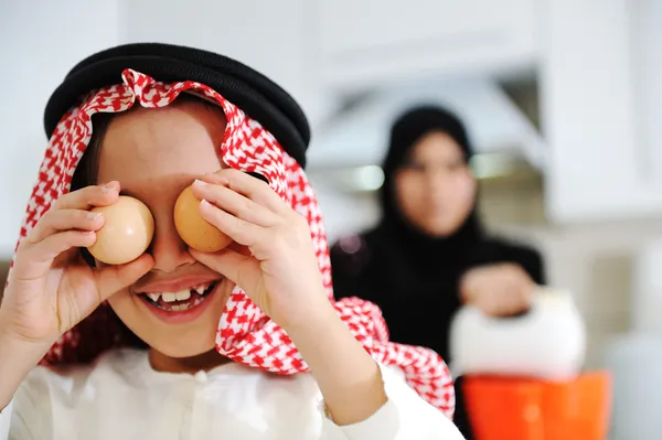 Мусульманская мать и маленький сын на кухне — стоковое фото